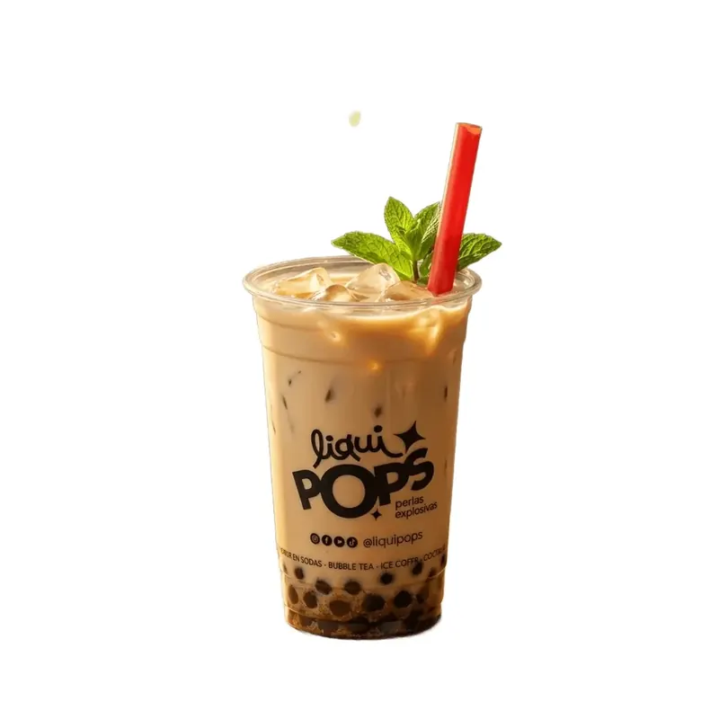 Vaso de bubble tea de café con leche, hielo y menta, con perlas oscuras en el fondo y sorbete rojo